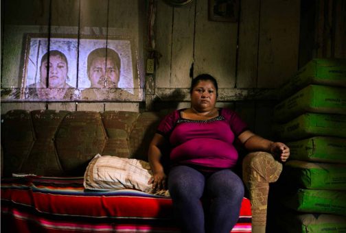 Yuni Ordoñez, widow of José Luis Pastrana. At only 26 years of age, Pastrana was the youngest of the campesinos killed on the El Tumbador plantation. Yuni is sitting in front of a projection of one of the few photographs of her husband she possesses. After she denounced the massacre, she suffered several attacks on her person, including being shot at. The day this photograph was taken, Yuni was suffering from an asthma attack but had no money to buy medicine.